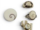 trois bijoux argentés et blancs posés sur un fond blanc