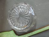 a clear glass bowl with a green spoon on a table