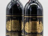 deux bouteilles de vin rouge posées l'une à côté de l'autre sur une surface blanche
