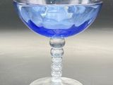 a blue glass bowl sitting on top of a table