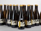 six bouteilles de vin sont alignées sur une table