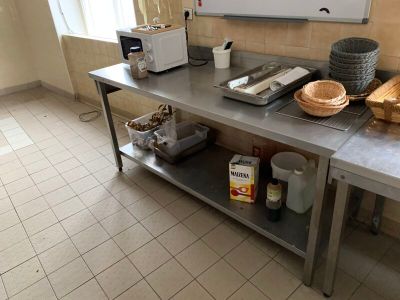 une cuisine équipée d'une table en inox et d'un micro-ondes