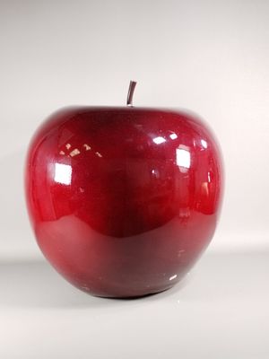 a red apple that is sitting on a white surface
