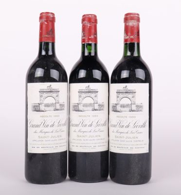 trois bouteilles de vin rouge posées l'une à côté de l'autre sur une surface blanche