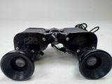 pair of black binoculars sitting on top of a white surface
