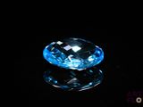 a close up of a blue diamond on a black surface