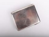 an image of a silver cigarette case sitting on top of a white surface