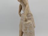 marble statue of a boy with a bucket of water on top of a rock