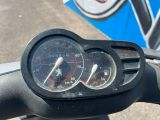 un gros plan sur le compteur de vitesse fixé sur le guidon d'une moto