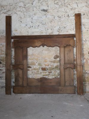 two pieces of wood sitting next to a stone wall