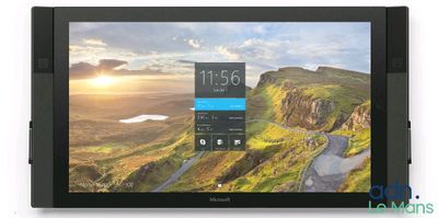 un gros plan d'une tablette posée sur une surface blanche, avec une montagne en arrière-plan