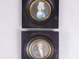 une paire de portraits miniatures représentant un homme et une femme, dans des cadres noirs