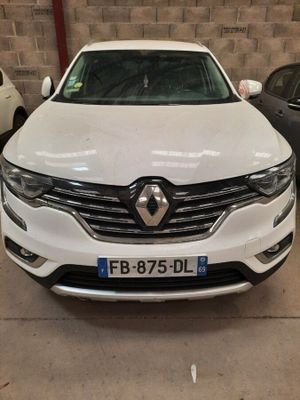 une voiture blanche garée dans un garage à côté d'autres voitures