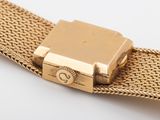 an image of a gold watch on a white surface