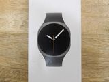 La montre Samsung est posée sur le couvercle de la boîte, sur la table.