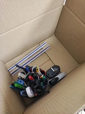 une boîte en carton contenant tout un tas de fournitures de bureau