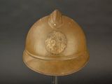 un casque en or orné d'un lion, posé sur un socle