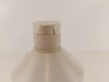 a bottle of liquid sitting on a white surface
