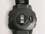 a close up of a black watch on a white surface