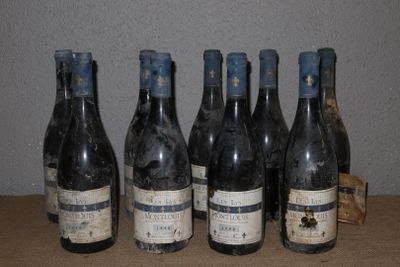 Six bouteilles de vin sont alignées sur une table devant un mur.