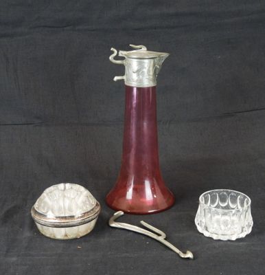 un vase en verre rouge et une assiette en argent sur fond noir