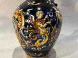 a blue and gold vase sitting on a white surface