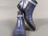 pair of men ' s blue leather ankle boots on a grey background