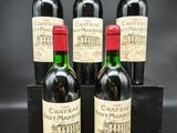 quatre bouteilles de vin du Château Lafitte présentées dans un coffret noir