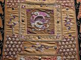 a very old embroidered cloth with a picture of a cat on it