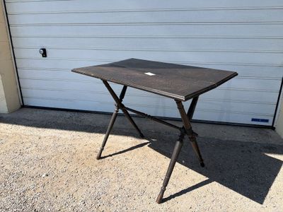 a small table with a laptop on it in front of a garage door