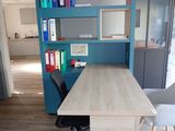 a desk with a chair and a book shelf in the corner