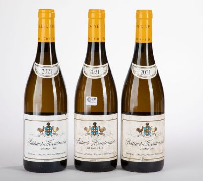 trois bouteilles de vin posées les unes à côté des autres sur une surface blanche