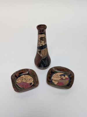 two small vases and a small bowl are sitting on a white surface