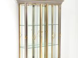 une grande vitrine aux portes en verre et aux finitions dorées