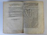 an open book with a picture of a letter m on it