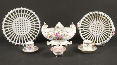 trois pièces de porcelaine différentes sur un fond noir, avec une grande roue