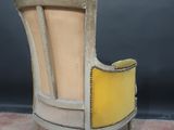 an old chair with a yellow seat is sitting on a pink carpet
