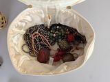 a white bag filled with assorted jewelry on a table