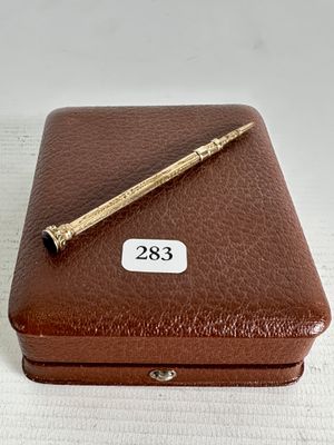 une boîte marron sur laquelle est posé un stylo
