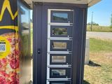 un distributeur automatique sur le côté duquel est posée une pizza