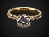 une bague de fiançailles en or sertie d'un diamant blanc sur fond noir