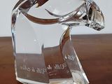 une figurine en verre représentant un oiseau, posée sur une table