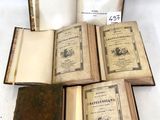 plusieurs vieux livres posés les uns sur les autres sur une table