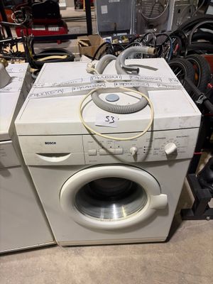 deux machines à laver placées l'une à côté de l'autre dans une pièce