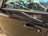 a black car with the door open and a steering wheel