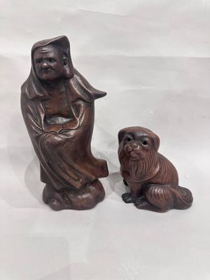 two figurines of a woman and a dog on a white background