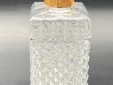 a clear glass bottle with a gold lid