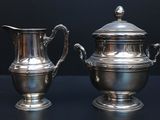 two silver vases sitting next to each other on a table