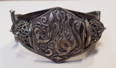 une photo d'un bracelet en argent orné de motifs complexes