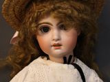 a doll that is wearing a hat and a dress